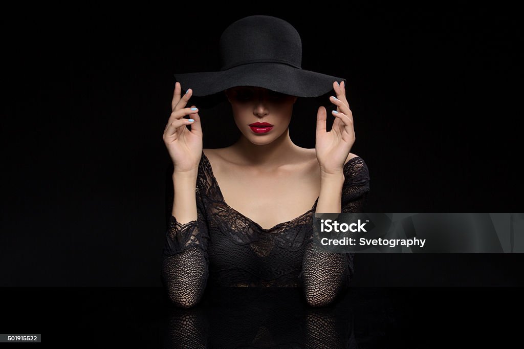 Beautiful girl with red llips in black hat Beautiful young woman with red llips in black hat. Over dark background. Copy space. 2015 Stock Photo