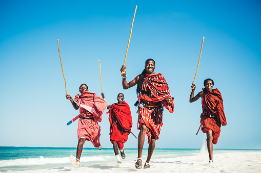 Masai warriors running on beautiful african beach, demonstrating their traditional hunting methods (zanzibar, Tanzania),