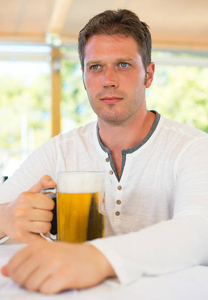 istock Handsome man with beer in summer cafe. 501917698