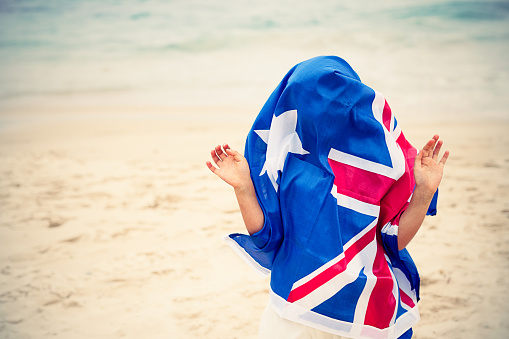 Preschool girl with Australian flag on the beach
