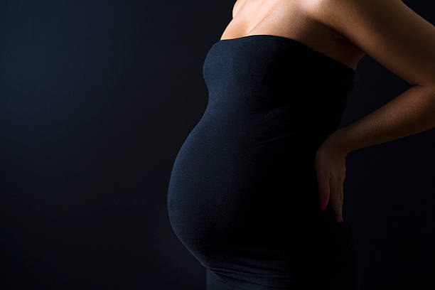 istock Beautiful pregnant woman with hands on her back 501934280