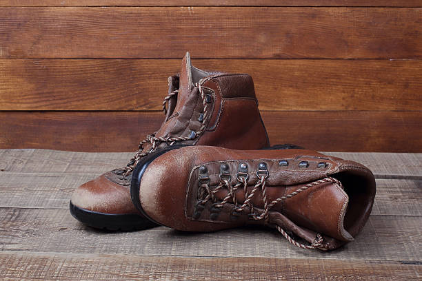 istock Old hiking boots on wooden background 501936416
