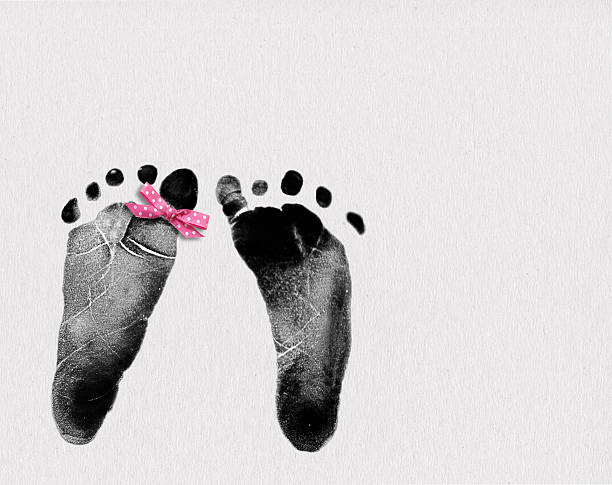 istock newborn footprint with pink bow 501938702