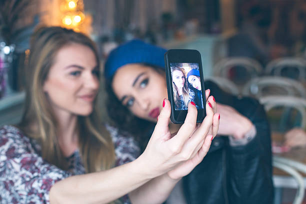 istock Two cheerful friends taking selfie in cafe 501939774