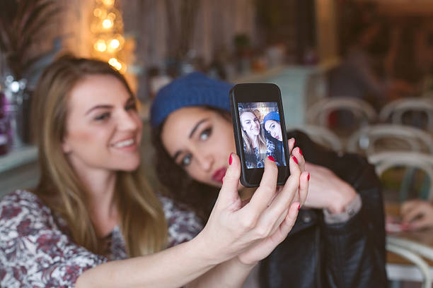 istock Two cheerful friends taking selfie in cafe 501939810