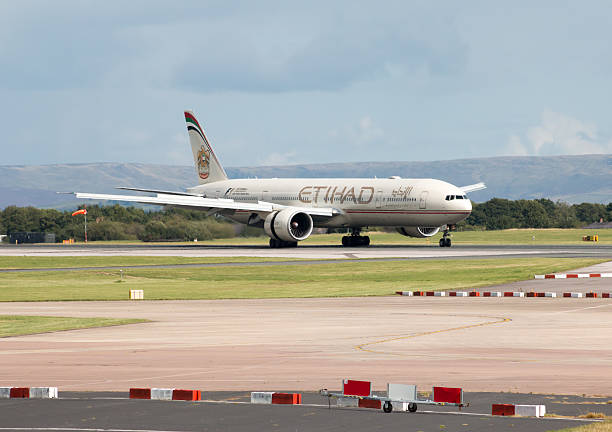 Manchester, United Kingdom - August 27, 2015: Etihad Airways Boeing 777 wide-body passenger plane (A6-ETF) taxiing on Manchester International Airport tarmac after landing.