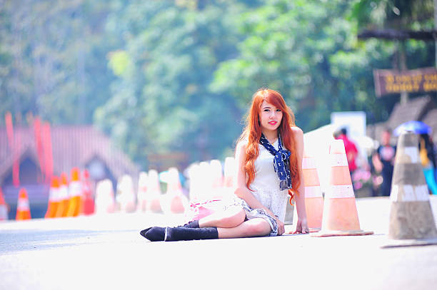 fashion of asia young women sitting on park way