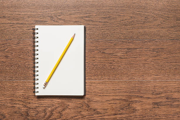 istock yellow pencil with blank note book on wooden background 501941700