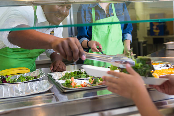 istock Cafeteria workers serving healthy meal to students in lunch line 501944945