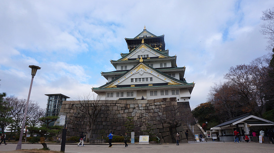 Osaka, Japan - December 24, 2013 : People at Osaka Castle. It is the most famous castle in Japan. It is located in Chuo-ku, Osaka, Japan. The castle is open to the public and it is a main tourist attraction in Osaka, Japan.