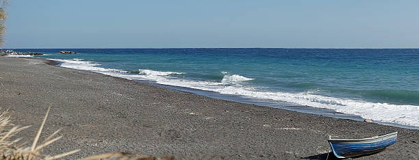 boot am vulkanischen strand auf der insel santorin - black sand beach santorini greece stock-fotos und bilder