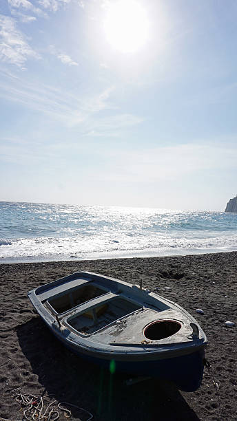 istock boat on volcanic beach at santorini island 501946644