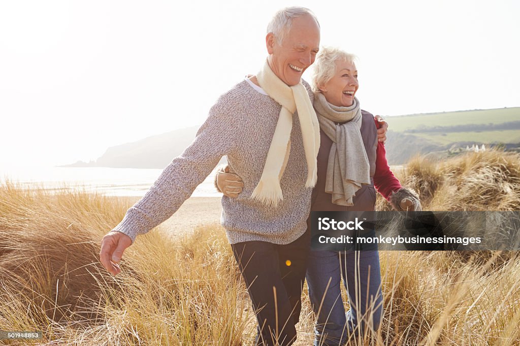 Altes Paar zu Fuß durch den Sand Dunes On Winter Beach - Lizenzfrei Alter Erwachsener Stock-Foto