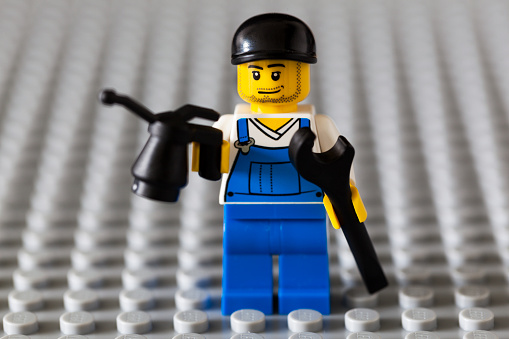 Copenhagen, Denmark - July 14, 2014: Lego mechanic with oil can and wrench. Lego is a Danish company which has been producing interlocking plastic bricks since 1949. Lego is one of the most well known brands in the world. Lego has opened theme parks and stores in several countries and they produce clothes, video games, movies etc.
