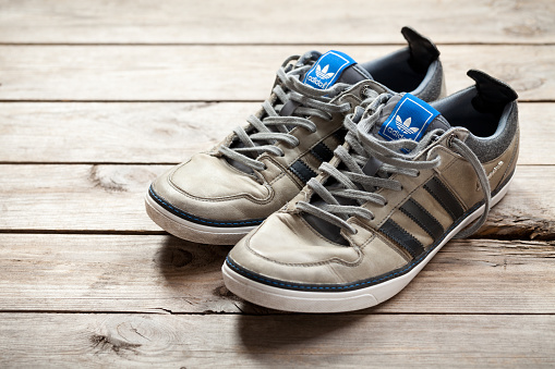 Jasien, Poland - June 13, 2014: Adidas shoes on old wood floor. Adidas AG is a German sports apparel manufacturer and parent company of the Adidas Group.