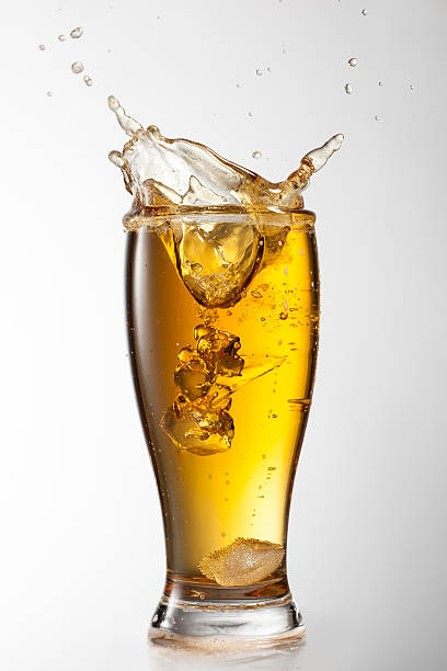 istock Ice falling into beer glass with splash isolated on white 501950859