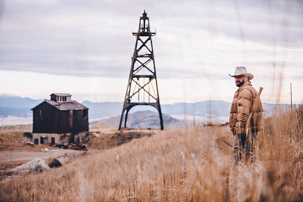 istock Rugged man stands in hay with barn and old machinery 501951785