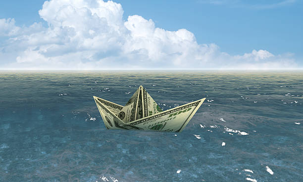 dollar bateau dans l'eau et économie concept - brunt photos et images de collection