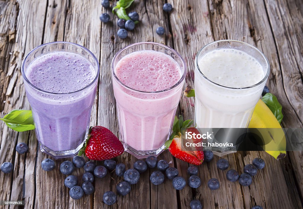 Fresh fruits milk shake on wood Fresh milk, strawberry, blueberry and banana drinks on wodeen table, assorted protein cocktails with fruits. Antioxidant Stock Photo