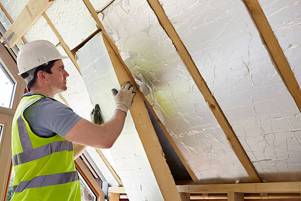 Builder Fitting Insulation Into Roof Of New Home stock photo