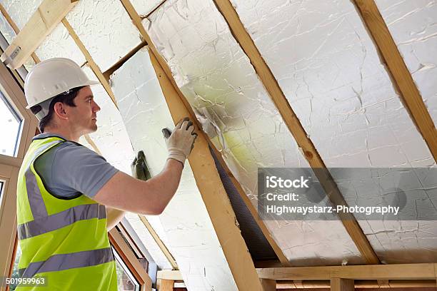 Builder Fitting Insulation Into Roof Of New Home Stock Photo - Download Image Now - Insulation, Rooftop, Home Interior