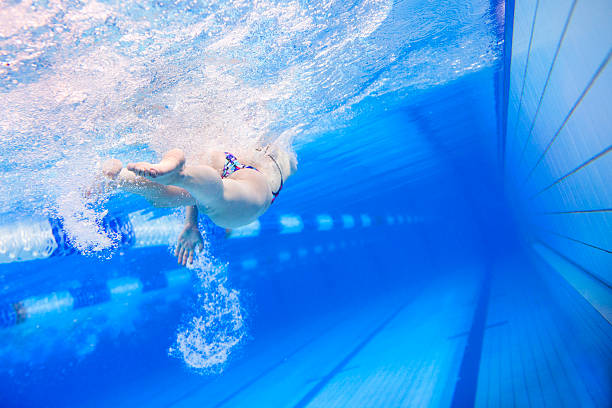 nadador avanzado a través de la piscina - swimming exercising women back fotografías e imágenes de stock