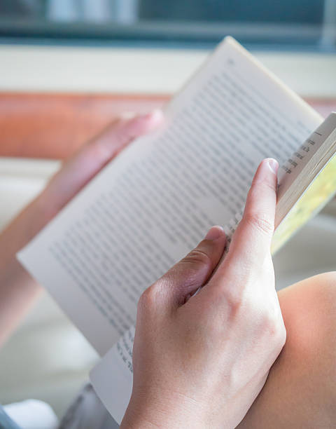 istock Hand holding book to read while sitting in a car 501963745