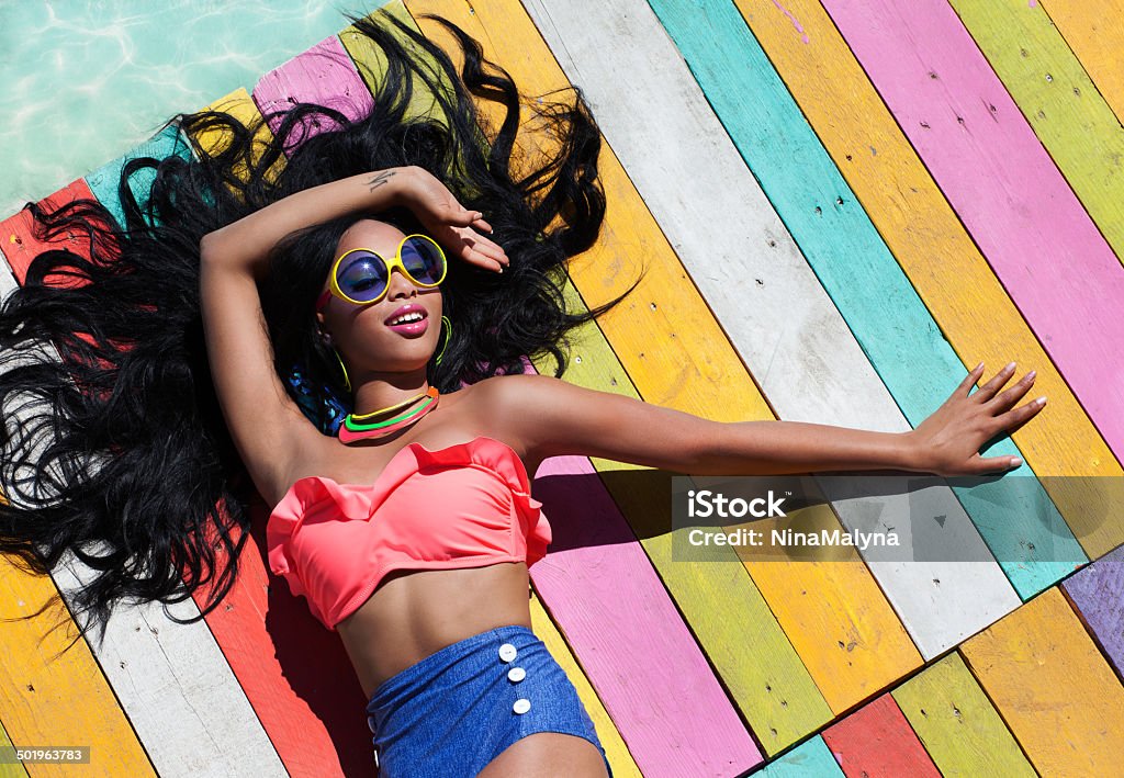 Tropical summer holiday fashion concept Tropical summer holiday fashion concept - tanning woman on a wooden pier  Women Stock Photo