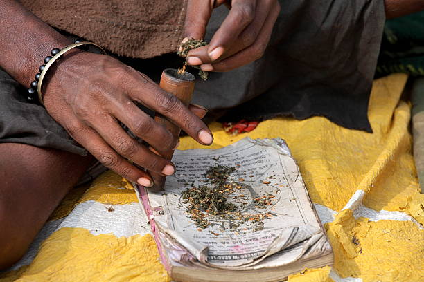 sadhu (aghori) ist das rauchen ganja (marijuana) mit chillum - indian ethnicity sadhu india pilgrim stock-fotos und bilder