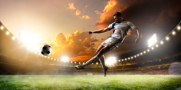 istock Soccer player in action on sunset stadium panorama background 501965258