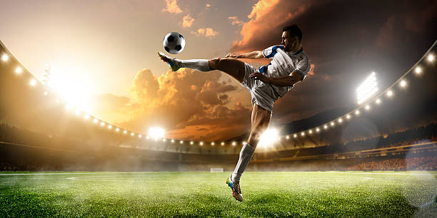 istock Soccer player in action on sunset stadium panorama background 501965272