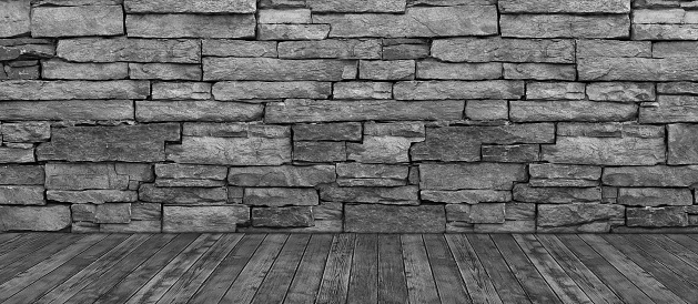 A black and white background of a rustic layered brick wall and a hardwood floor.