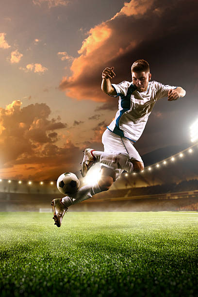 istock Soccer player in action on sunset stadium background 501965332