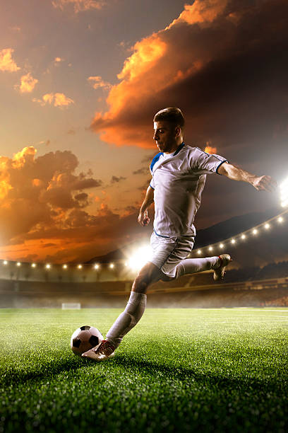 istock Soccer player in action on sunset stadium background 501965370