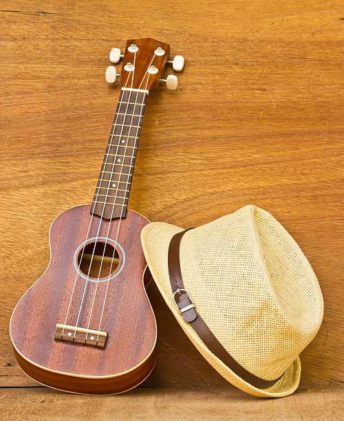 istock ukulele and a hat is placed on a wooden floor. 501965477
