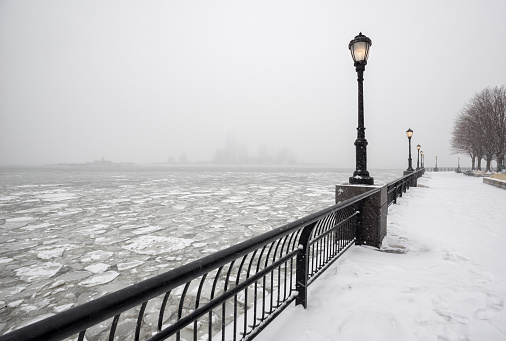 Frozen Hudson River from snowy Battery Park towards Jersey City in fog. A silent winter day in New York City. 
