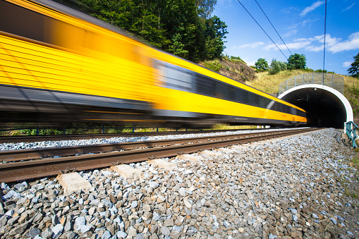 Fast train passing through a tunnel on a lovely summer day (motion blurred image)