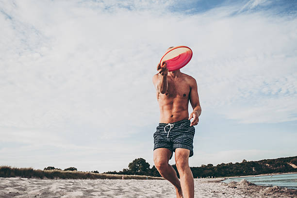 istock Relaxed man playing frisbee on beach in Germany 501966060