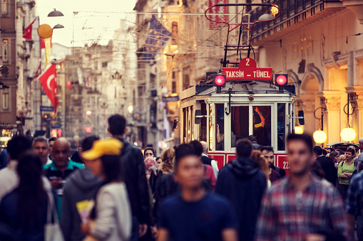 Tramway passing through large crowded Istiklal street in Taksim, Beyoglu, Istanbul, Turkey.