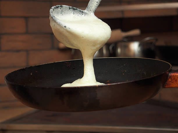 istock Pouring batter with a ladle. Making yeast pancakes (crepes). 501969668