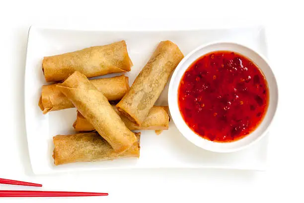 Spring rolls with chili sauce and chopsticks.  Overhead view.