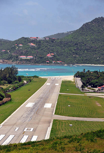 St Barts airport runway St Barts airport runway ending on the beach - Gustaf III Airport seen from the hills - Saint Barthélemy Airport - Aérodrome de St Jean (IATA: SBH, ICAO: TFFJ), Plaine de la Tourmente, Saint Jean, St. Barts / Saint-Barthélemy - photo by M.Torres st jean saint barthelemy stock pictures, royalty-free photos & images