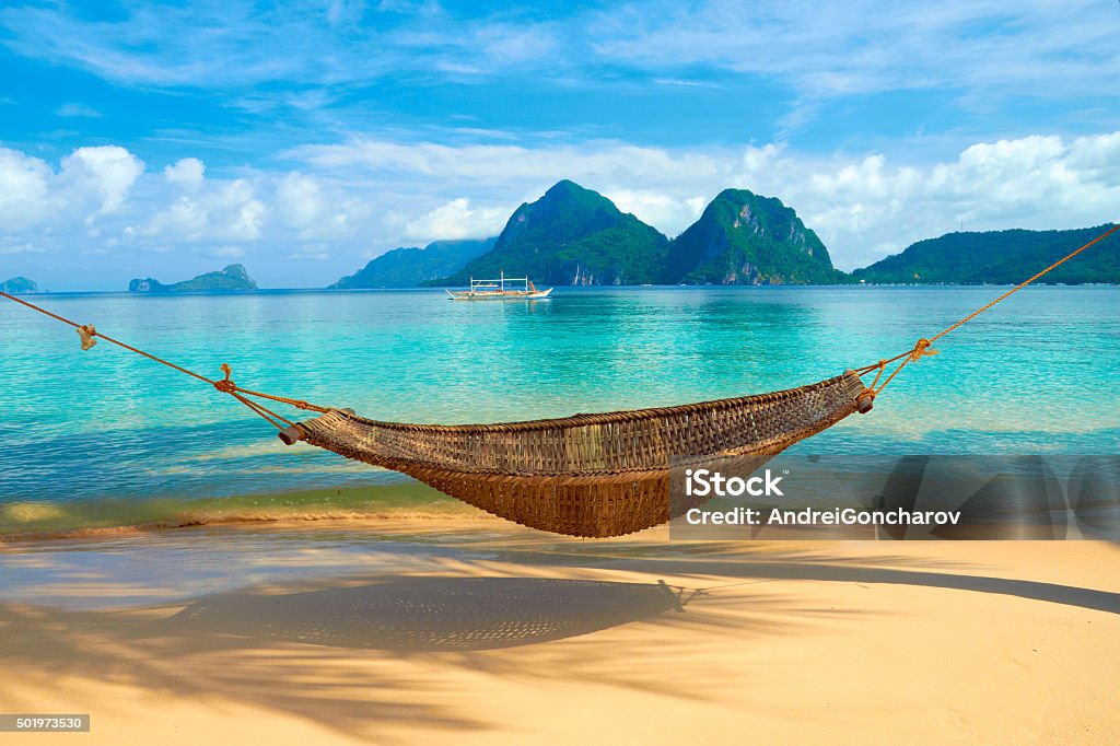 Hammock at the Beach A hammock at the beach with the view of Bacuit Archipelago islands - El Nido, Philippines Beach Stock Photo