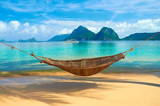 Hammock at the Beach A hammock at the beach with the view of Bacuit Archipelago islands - El Nido, Philippines perfection stock pictures, royalty-free photos & images