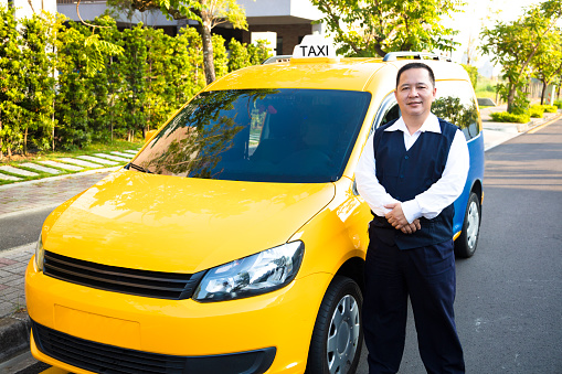 portrait of smiling taxi driver with car