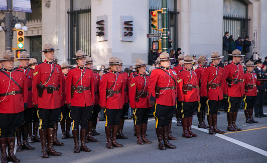 Vancouver, BC, Canada – November 11, 2015: Members of the Royal Canadian Mounted Police (RCMP) dressed in their traditional red serge uniforms standing at attention during Remembrance Day ceremonies in Vancouver, British Columbia.