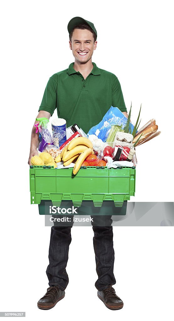 Delivery man Full lenght portrait of delivery man carrying box with groceries. Studio shot, white background. Delivery Person Stock Photo