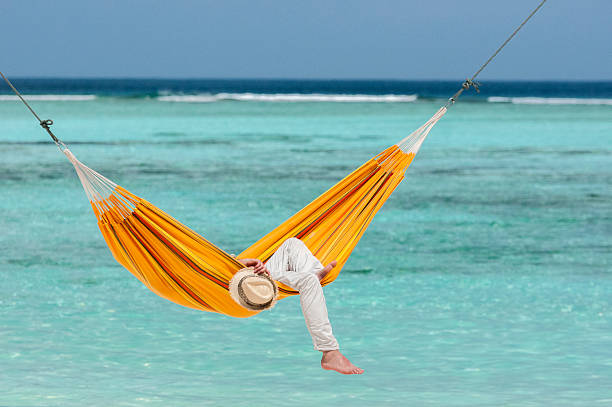 istock Young man having a nap in a orange hammock 501996385