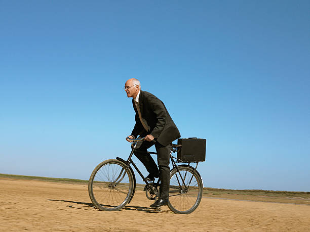istock Businessman Riding Bicycle In Desert 501996699