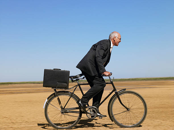 istock Businessman Riding Bicycle In Desert 501996703